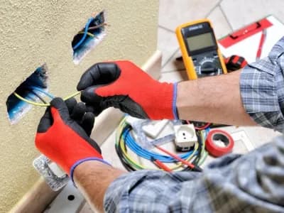 Person working on home electrical wiring.