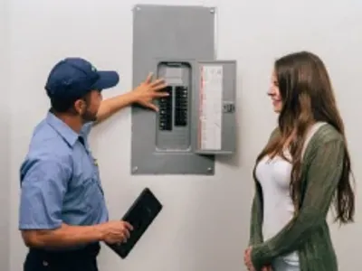 Customer with electrician viewing circuit breaker.