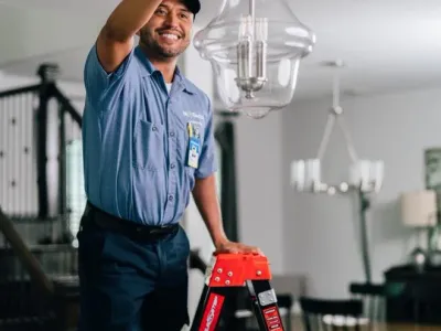 Electrician adjusting chandelier.