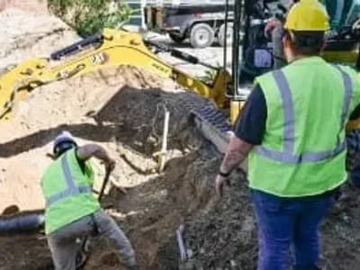 workers using mechanical plumbing excavator