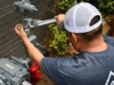 worker using wrench to tighten gas plumbing pipes