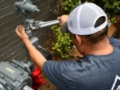 worker using wrench to tighten gas plumbing pipes