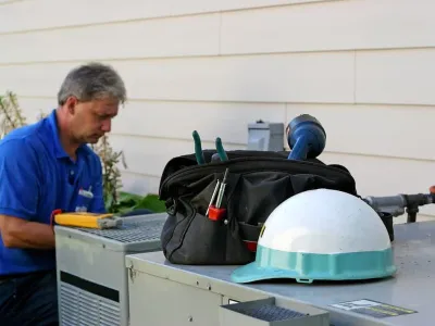 HVAC technician servicing outdoor air conditioning unit during emergency repair