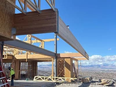 Construction site with wooden framing and clear blue sky in a desert landscape.