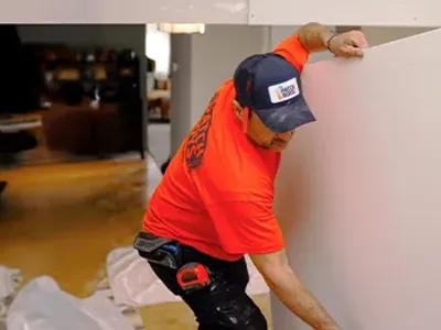 Technician carrying drywall