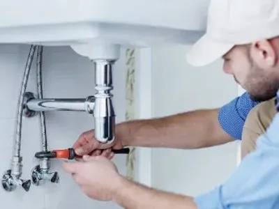 plumber working under a sink