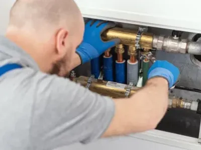 Professional plumber installing plumbing manifolds at home, home improvement and repair concept
