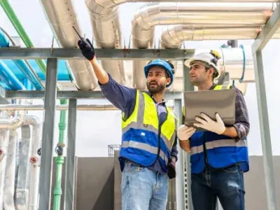 Collaboration, Two contractors inspecting plumbing in a commercial building