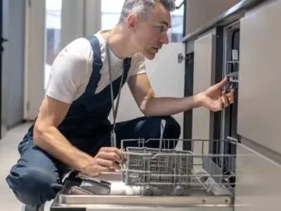 Plumber Fixing A Dishwasher