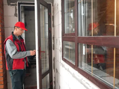 Person in red hat opening glass door.