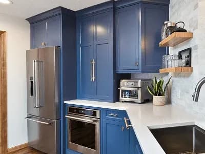 Modern kitchen with blue cabinets and appliances.