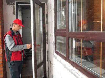 Person in red hat opening glass door.