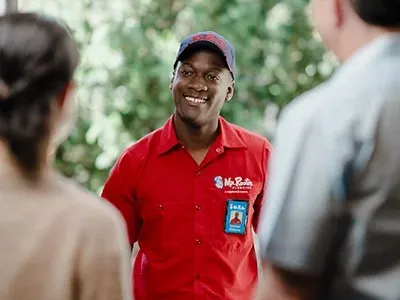 Mr. Rooter professional greeting customer's at their front door.