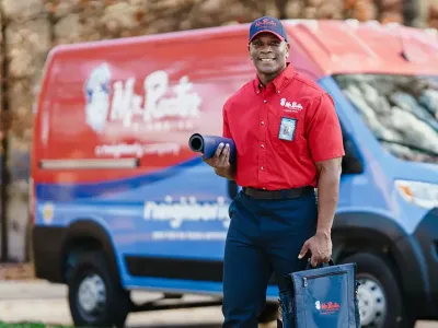 Mr. Rooter professional standing by a branded van.