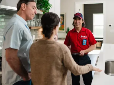 Mr. Rooter professional speaking with customers inside their home.