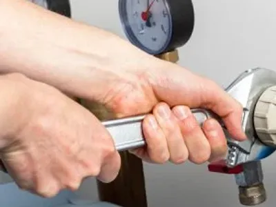 Hands repairing valves in boiler room
