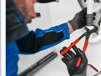 Plumber working in kitchen, Repair man service, repairing leaking water from sinks with red wrench