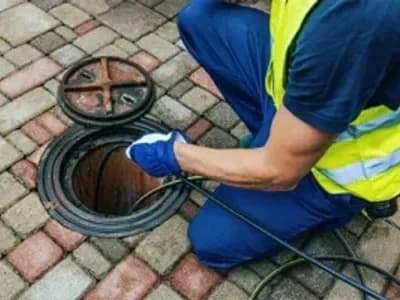 service worker cleaning blocked sewer line with hydro jetting