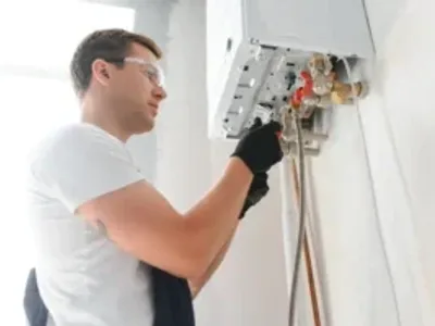 Professional plumber checking a boiler and pipes, boiler service concept.