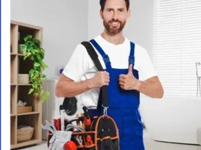 Plumber with bag of instruments showing thumbs up in bathroom