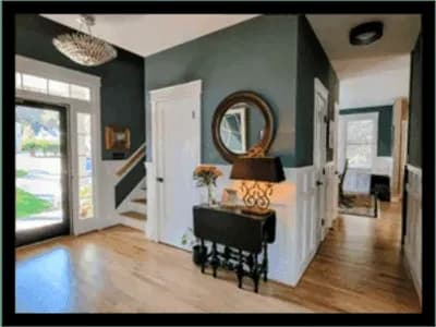 Cozy entryway with a staircase, mirror, and a piano bench.