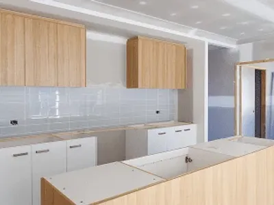 Modern kitchen under construction with wooden cabinets.