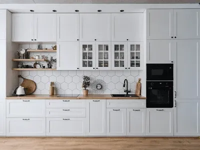 Modern kitchen with white cabinets and backsplash.
