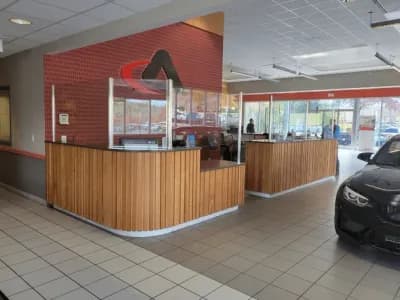 Reception desk in a modern office with wood paneling and glass partitions.