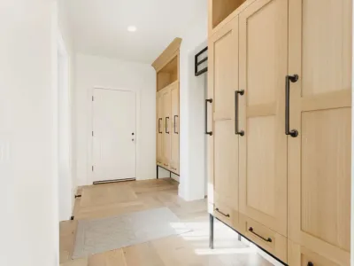 mudroom with light wood cabinets & dark handles by 10x builders in utah county