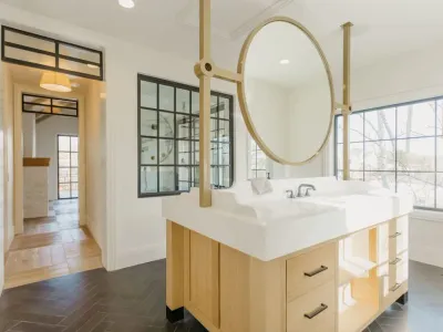bathroom with island sink & large gold mirror by 10x builders in utah county