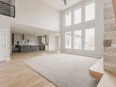 living area with large windows & carpet by 10x builders in utah county