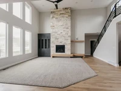 living area with vaulted ceiling and stone fireplace by 10x builders in utah county