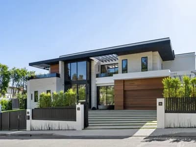 A modern two-story custom home featuring white siding, black window frames, and a clean contemporary architectural design.