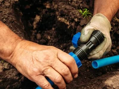 A technician conducts an irrigation system repair.