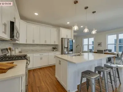 Professional painter spray-applying white finish to kitchen cabinet doors in Nashville, TN
