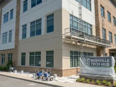 Professional commercial exterior painting on a Nashville office building with fiber cement and brick facade