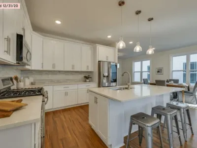 Professional painter spray-applying white finish to kitchen cabinet doors in Nashville, TN