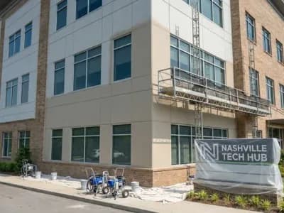 Professional commercial exterior painting on a Nashville office building with fiber cement and brick facade