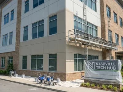 Professional commercial exterior painting on a Nashville office building with fiber cement and brick facade