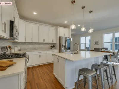 Professional painter spray-applying white finish to kitchen cabinet doors in Nashville, TN