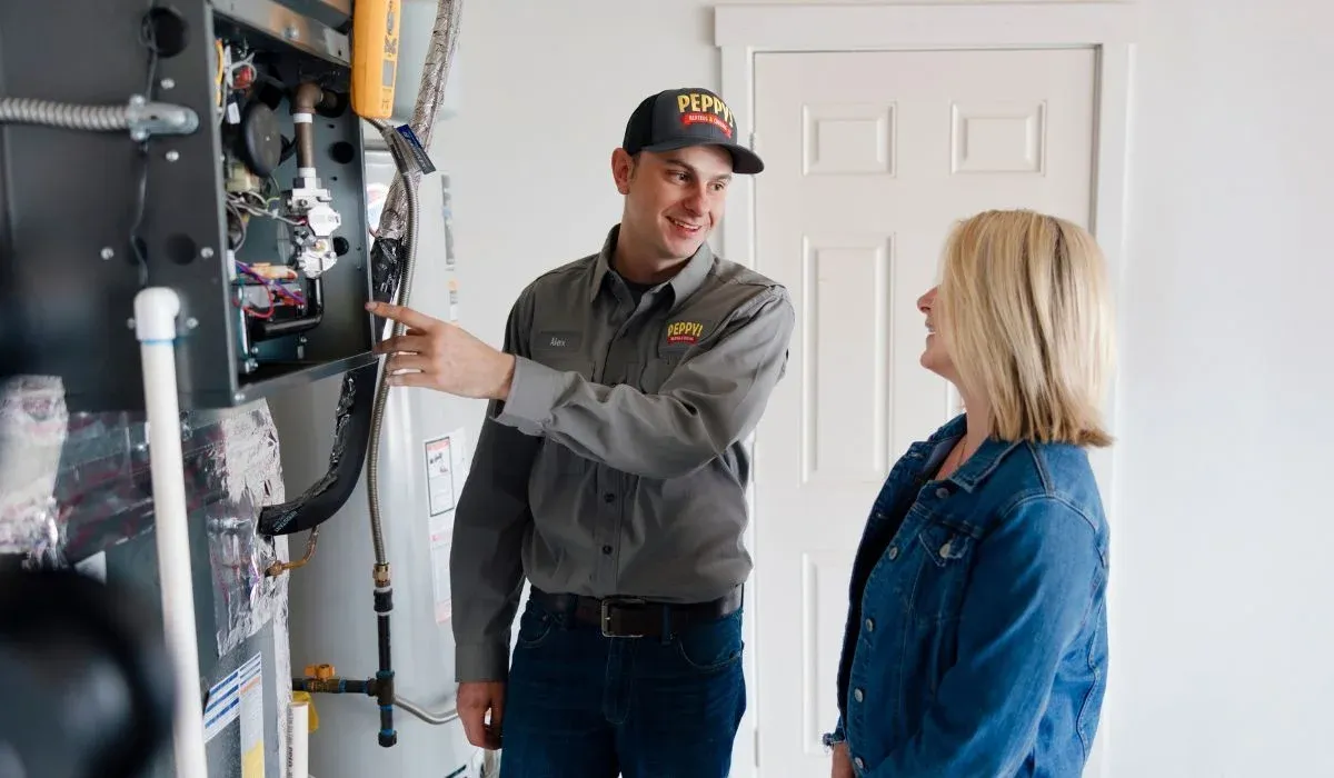 Image of a technician showing a customer their furnace