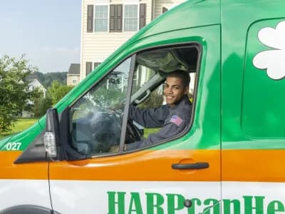 HARP Home Services technician smiling from the repair vehicle