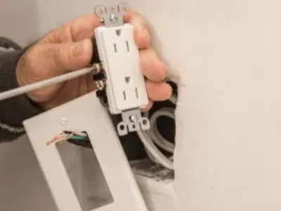Electrician adjusting electric outlet