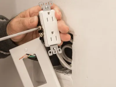 Electrician adjusting electric outlet