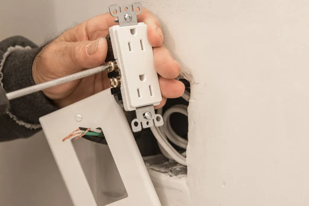 Electrician adjusting electric outlet
