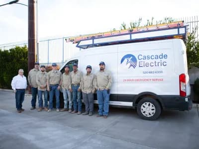 Team of 8 electricians standing in front of a Cascade Electric truck