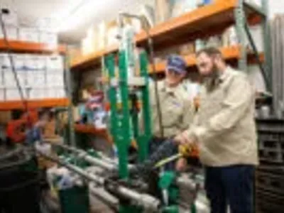 2 electricians measuring and cutting pipes