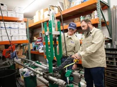 2 electricians measuring and cutting pipes