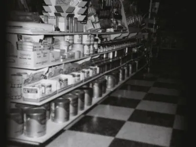 buckets of paint on a shelf on the store.