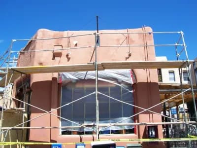 scaffolding surrounding the exterior of a newly plastered home